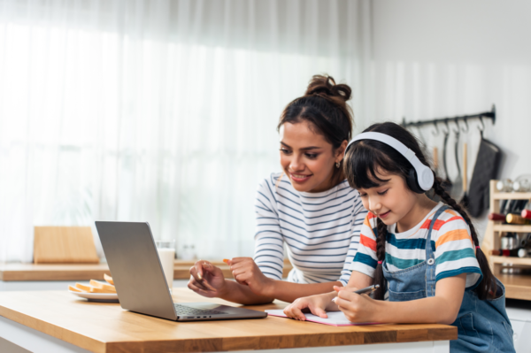 Madre apoyando a su hija en una clase de refuerzo escolar online con estrategias adaptadas para niños con TDAH.